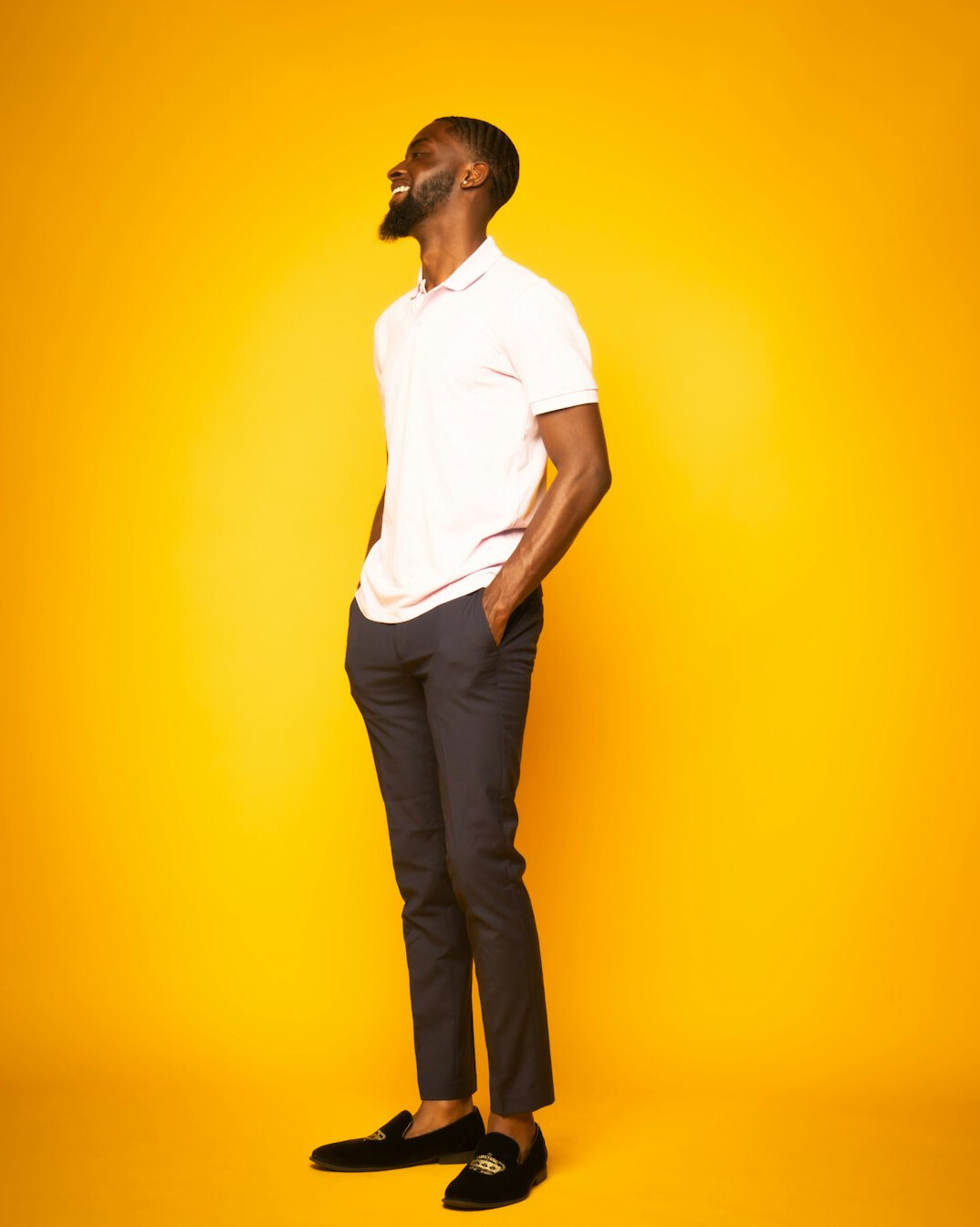 Studio portrait of a Black man with a beard smiling in business casual attire